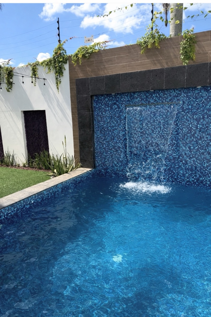 Alberca con cascada y muro de mosaico veneciano, Casa Cluster 12, Real Campestre