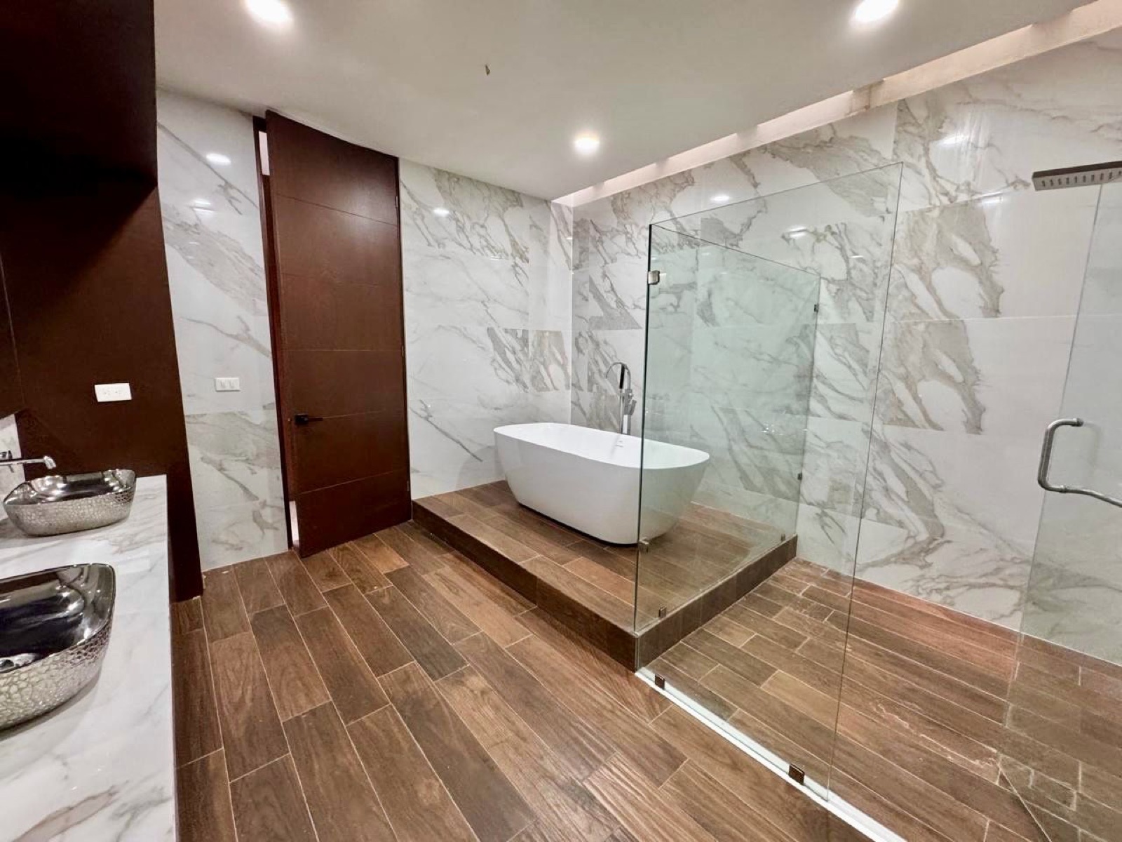 Baño principal con tina exenta, regadera walk-in y mármol, Casa Cluster 4