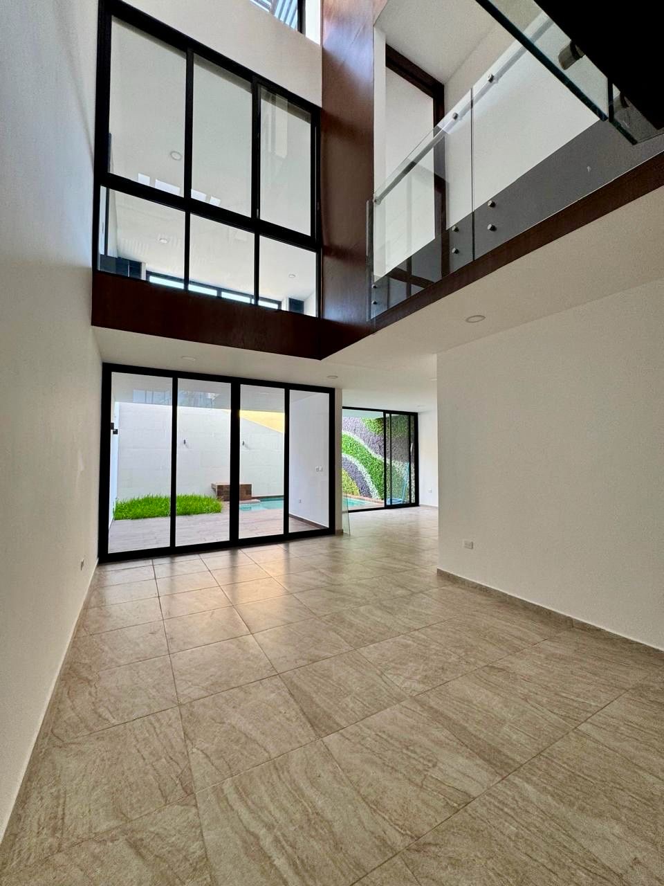 Sala a doble altura con ventanales de piso a techo y vista a la alberca, Casa Cluster 4