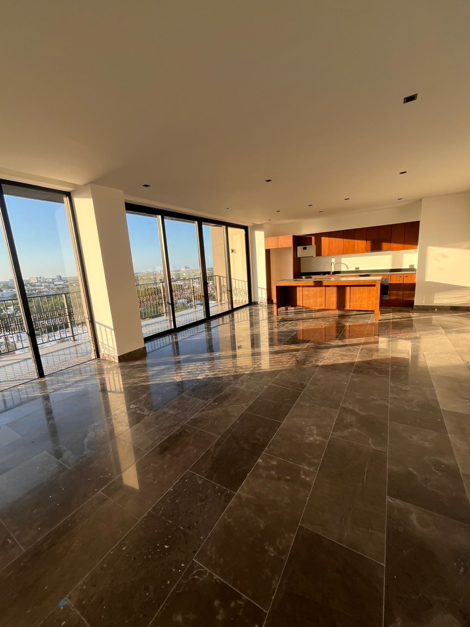 Sala comedor con ventanales piso a techo y pisos de mármol, departamento en piso 11, Mérida