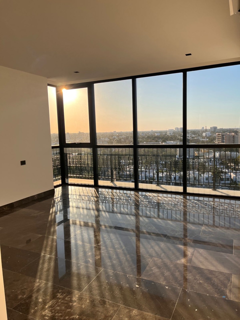 Esquina de cristal con vista panorámica de Mérida al atardecer, departamento en piso 11